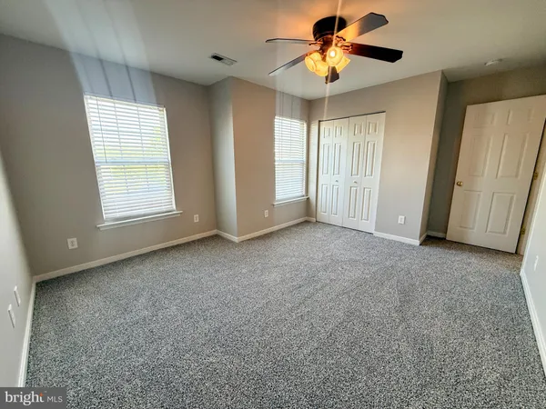 a view of an empty room and a ceiling fan