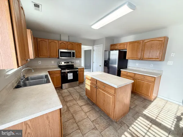 a view of a kitchen with granite countertop a stove top oven a sink and dishwasher