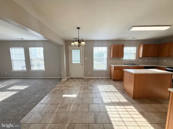 a view of an empty room with a fireplace and a window