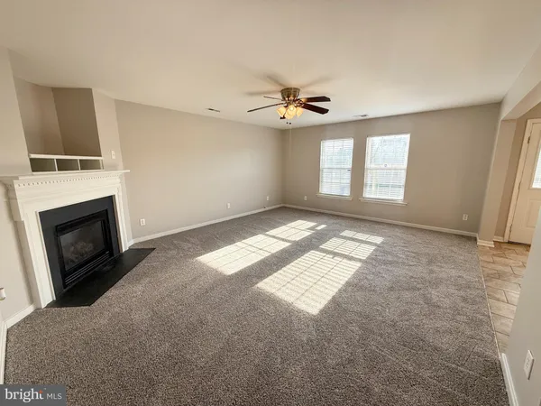 an empty room with windows and fireplace