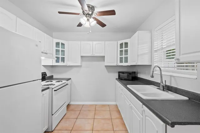 a kitchen with granite countertop a sink stainless steel appliances and cabinets