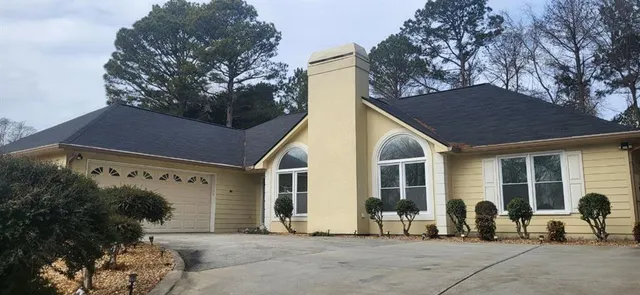 a view of a chairs and table in backyard of house