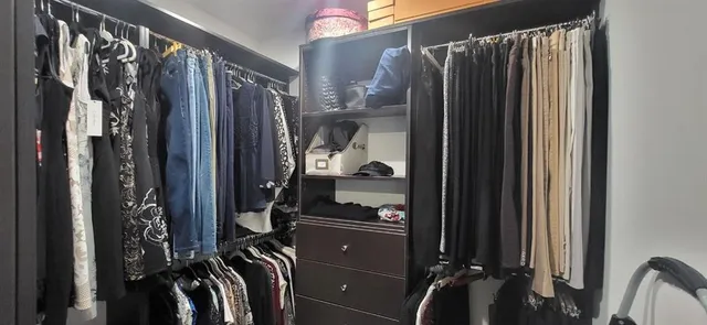 a view of walk in closet with clothes and shoes