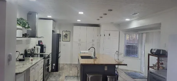 a view of a kitchen area with furniture and wooden floor