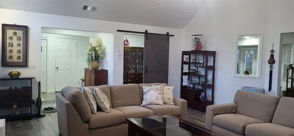 a living room with furniture and a book shelf
