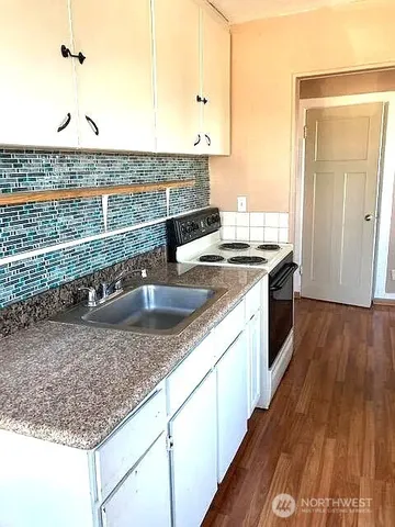 a view of a kitchen with kitchen island a sink appliances and a counter space