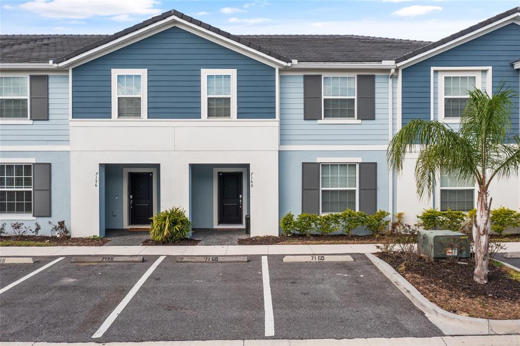 7160 Oakmoss Loop Davenport, FL 33837 - Photo 1 of 45 a front view of a house with yard and glass windows