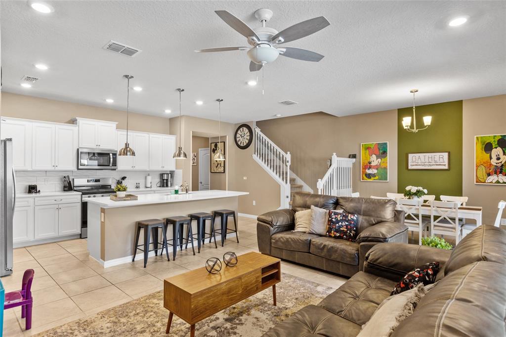 7160 Oakmoss Loop Davenport, FL 33837 - Photo 12 of 45 a living room with furniture kitchen view and a wooden floor