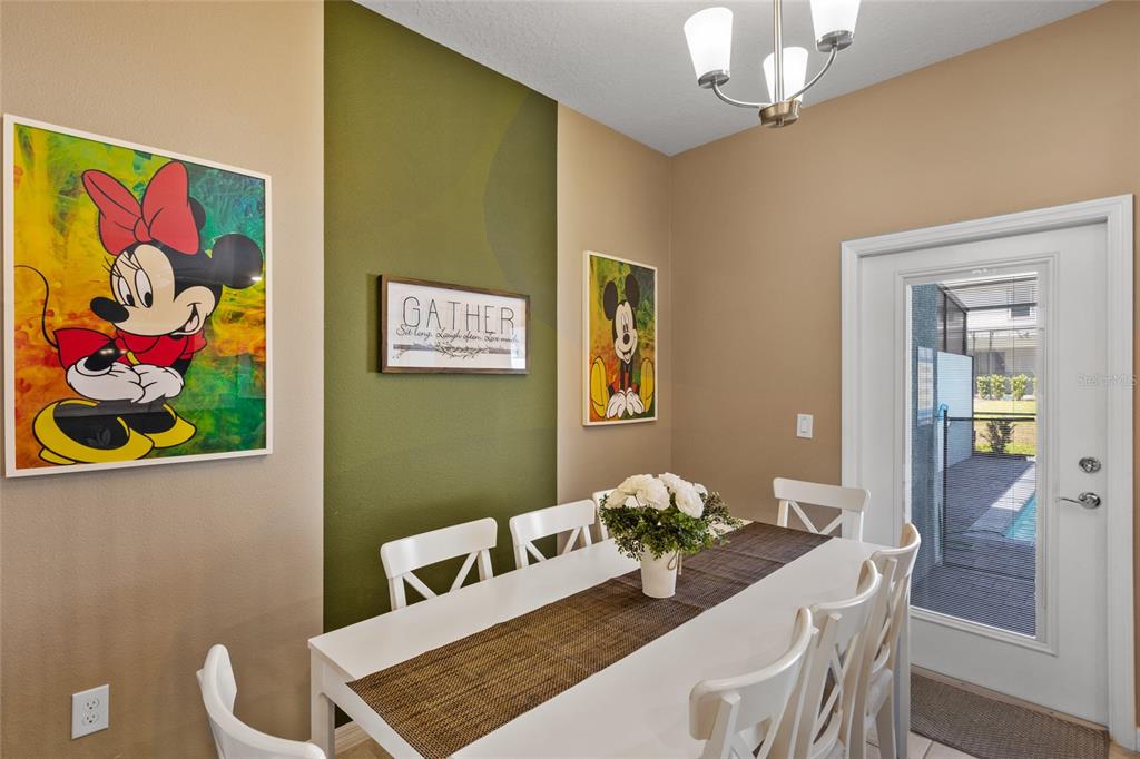 7160 Oakmoss Loop Davenport, FL 33837 - Photo 13 of 45 a view of a dining room with furniture wooden floor and a chandelier