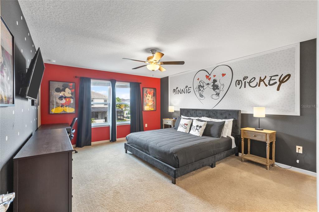 7160 Oakmoss Loop Davenport, FL 33837 - Photo 18 of 45 a bedroom with a bed and a chandelier