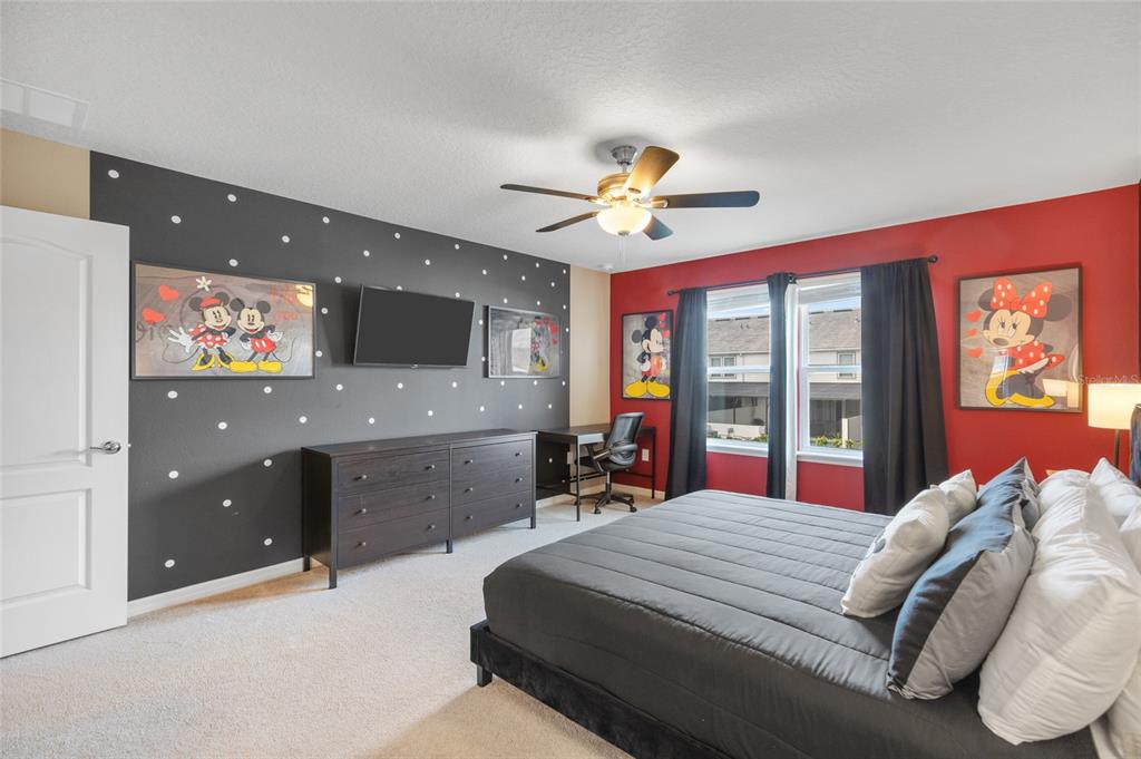 7160 Oakmoss Loop Davenport, FL 33837 - Photo 19 of 45 a bed room with a bed and a chandelier