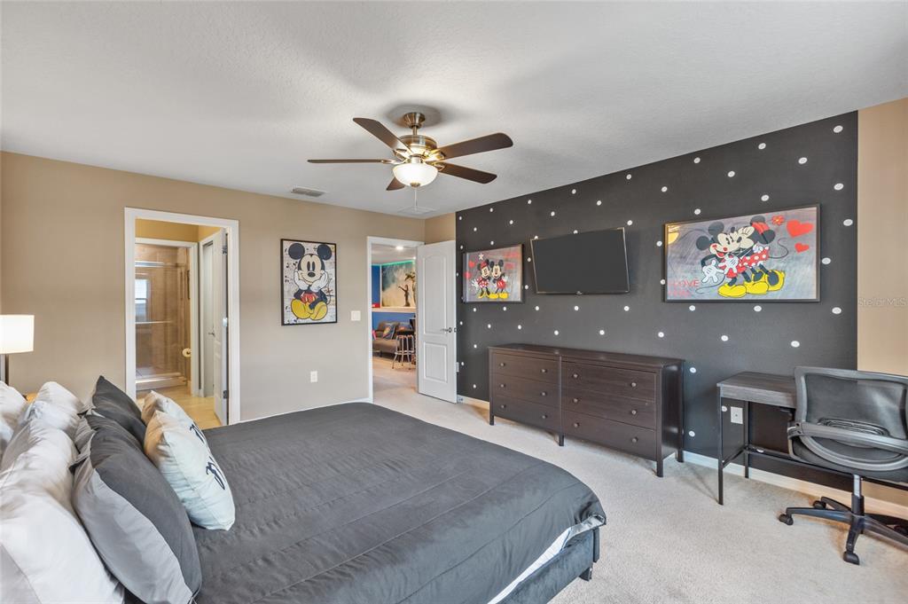 7160 Oakmoss Loop Davenport, FL 33837 - Photo 20 of 45 a bedroom with a bed and a chandelier