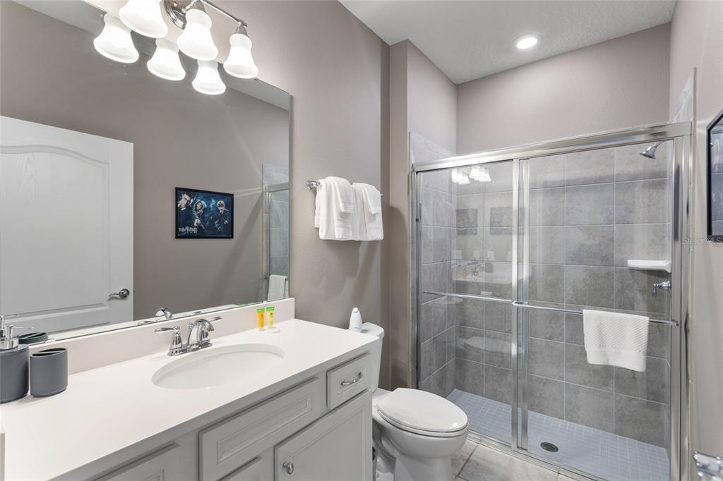 7160 Oakmoss Loop Davenport, FL 33837 - Photo 25 of 45 a bathroom with a sink a toilet a mirror and shower