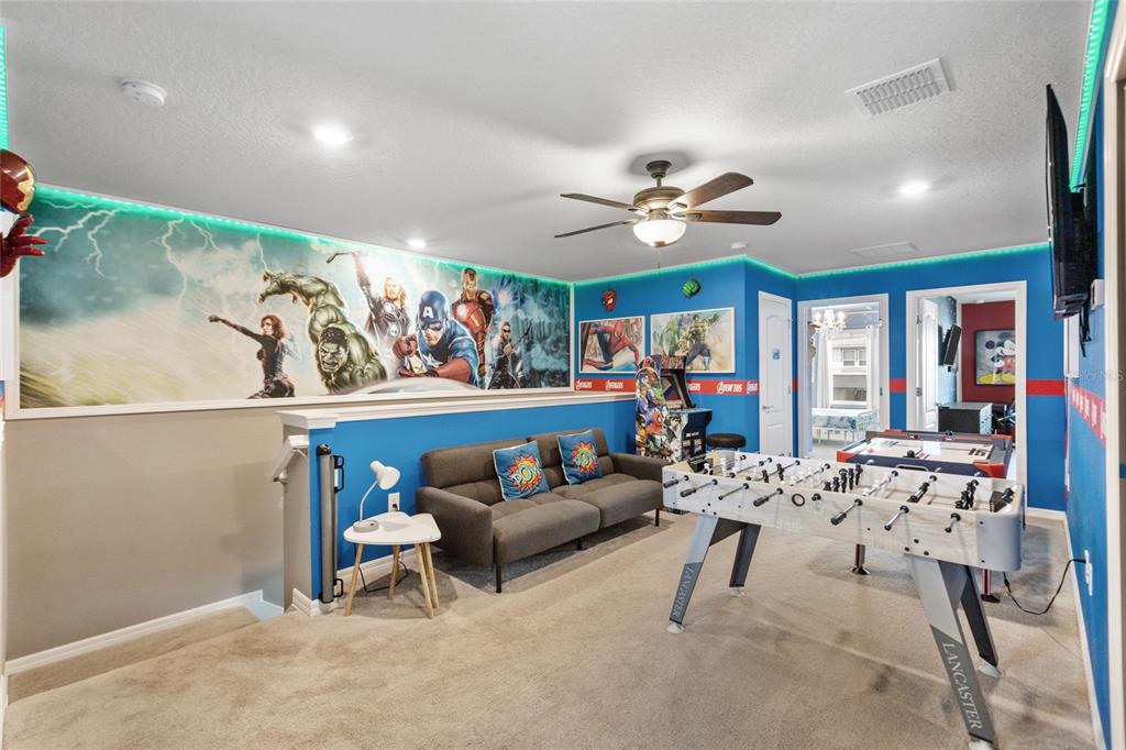 7160 Oakmoss Loop Davenport, FL 33837 - Photo 32 of 45 a living room with furniture a chandelier and a flat screen tv