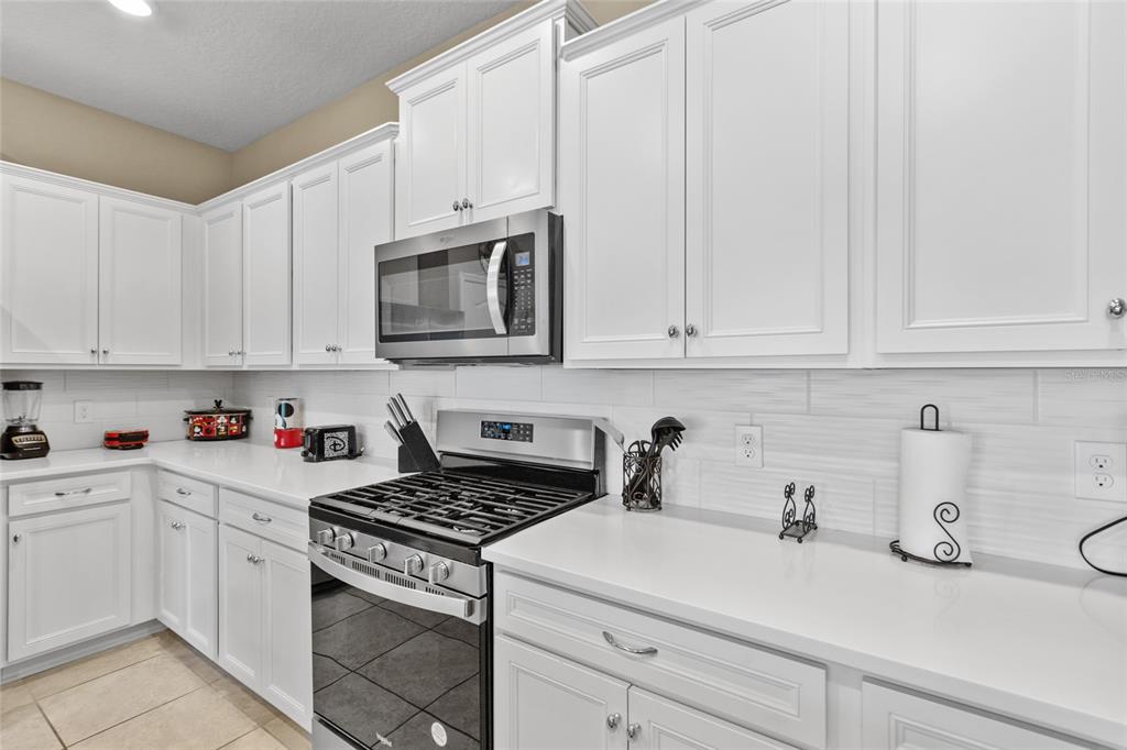 7160 Oakmoss Loop Davenport, FL 33837 - Photo 6 of 45 a kitchen with cabinets appliances a sink and a counter top