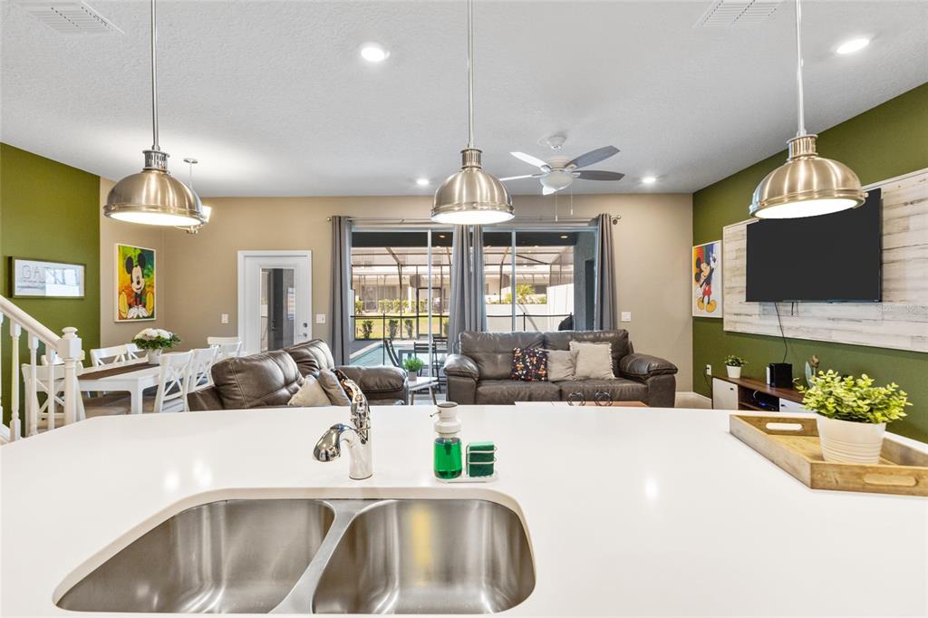 7160 Oakmoss Loop Davenport, FL 33837 - Photo 7 of 45 a view of a kitchen with granite countertop a sink a counter top space and living room view