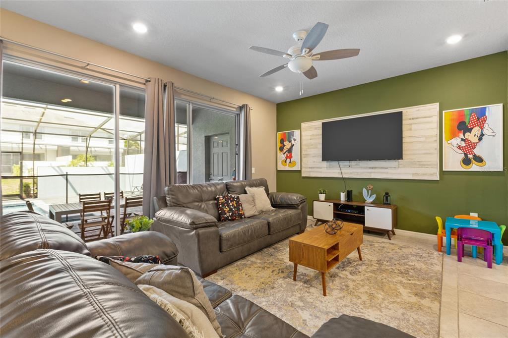 7160 Oakmoss Loop Davenport, FL 33837 - Photo 9 of 45 a living room with furniture and a flat screen tv