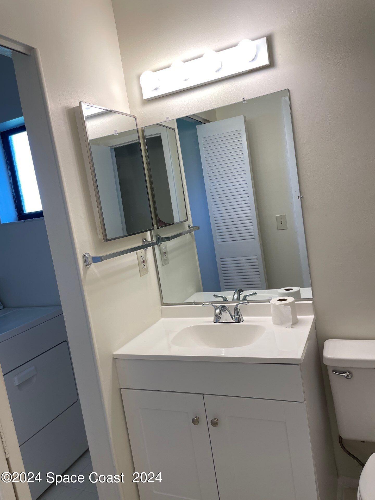 3250 Beach View Way Melbourne Beach, FL 32951 - Photo 5 of 7 a bathroom with a sink a mirror and vanity