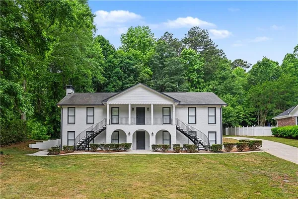 a front view of a house with a garden and plants