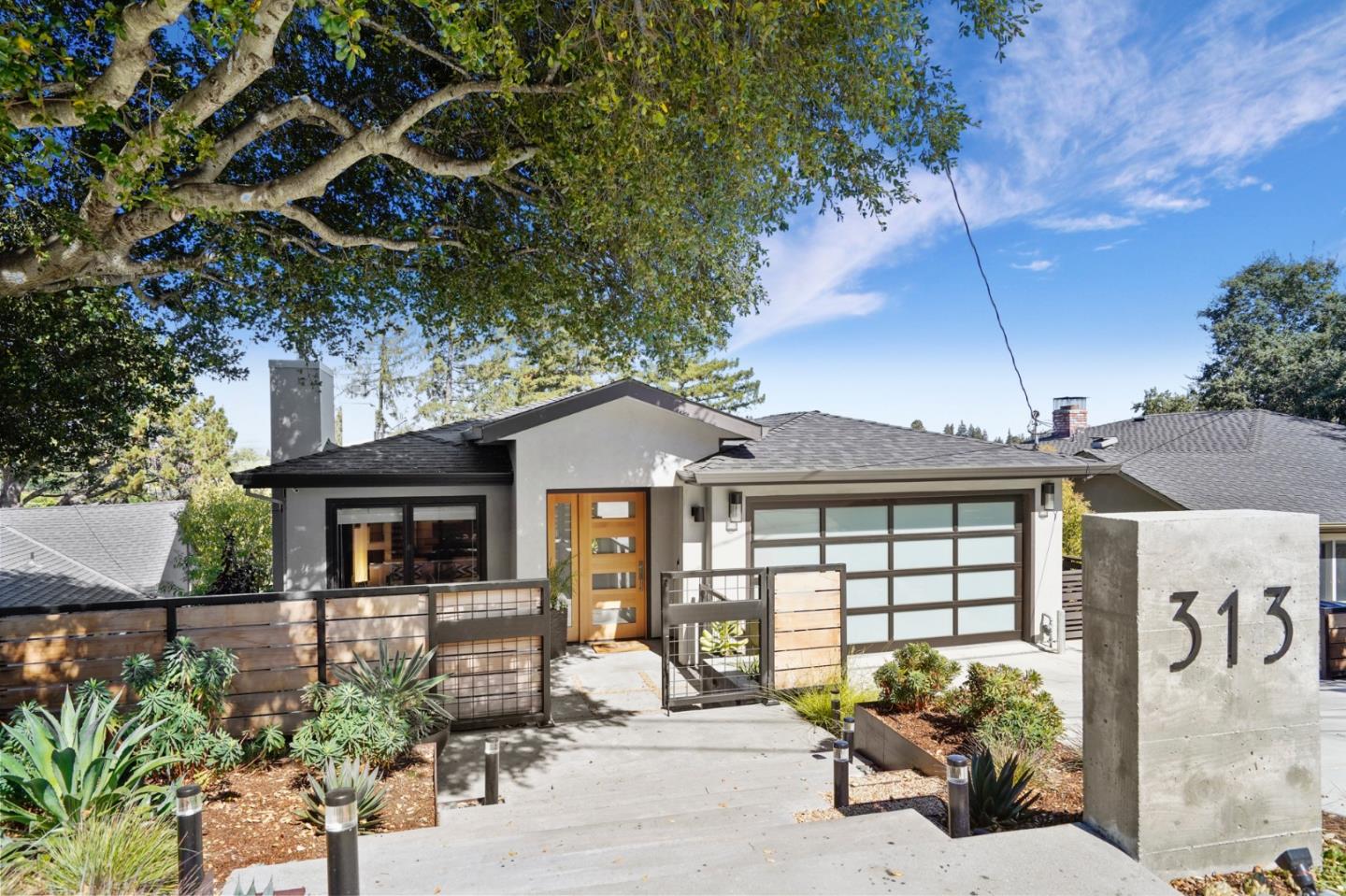 a front view of a house with a garden and sitting area