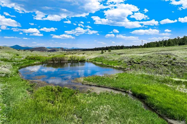 a view of a lake with lawn chairs