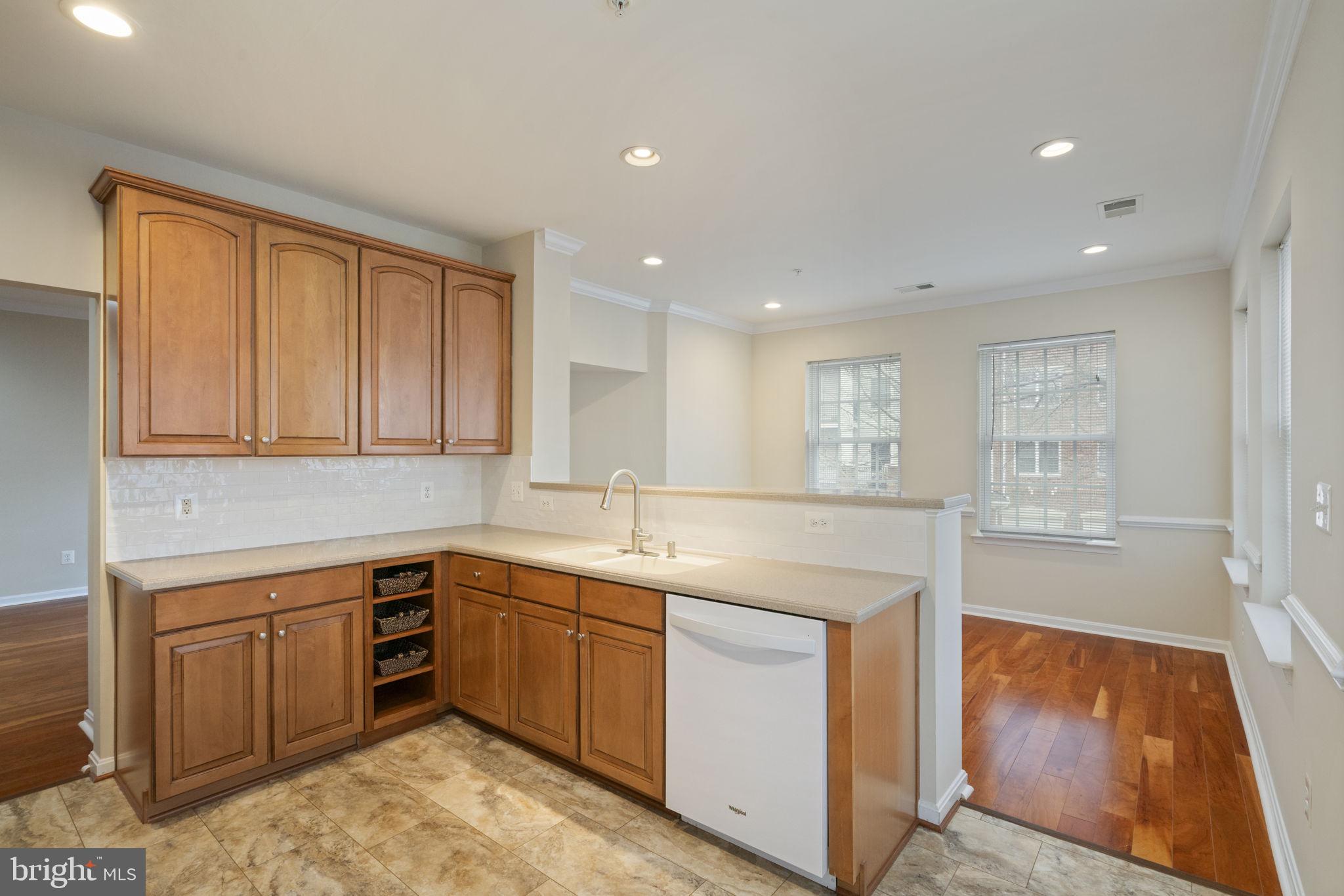 20751 Royal Palace Square, Unit 104 Sterling, VA 20165 - Photo 12 of 44 a kitchen with a sink stove and cabinets