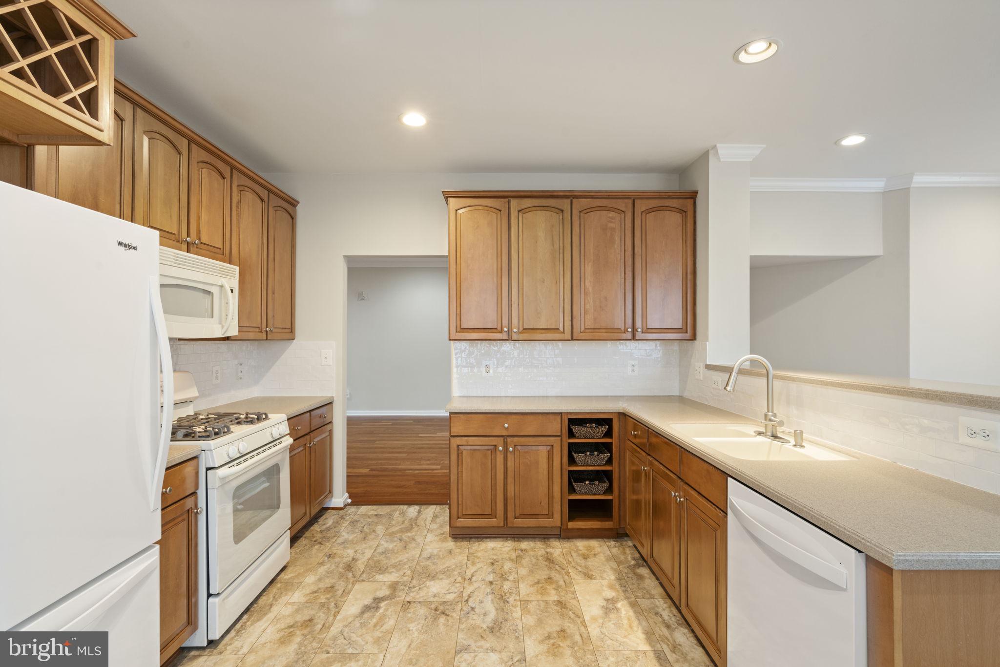 20751 Royal Palace Square, Unit 104 Sterling, VA 20165 - Photo 13 of 44 a kitchen with a sink stove and cabinets