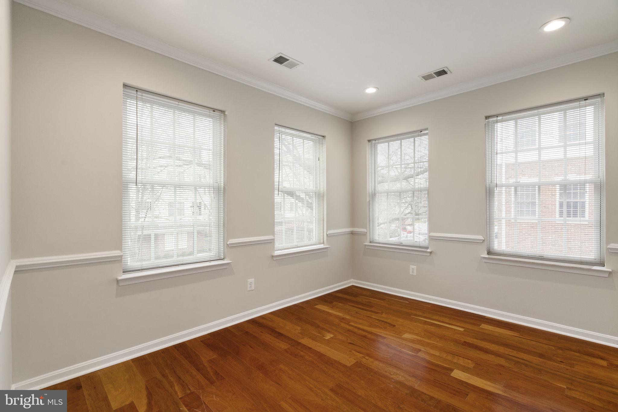 20751 Royal Palace Square, Unit 104 Sterling, VA 20165 - Photo 18 of 44 a view of an empty room with wooden floor and a window