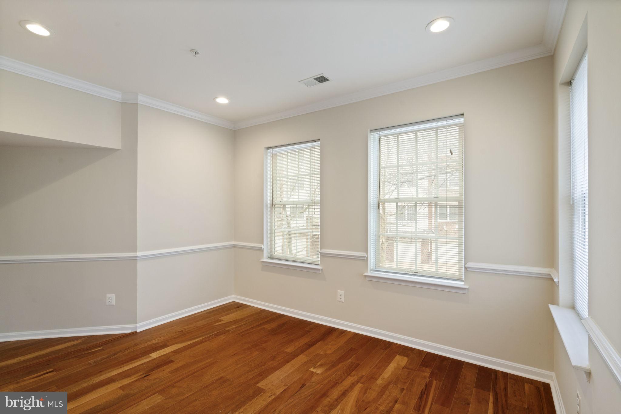 20751 Royal Palace Square, Unit 104 Sterling, VA 20165 - Photo 20 of 44 an empty room with wooden floor and windows