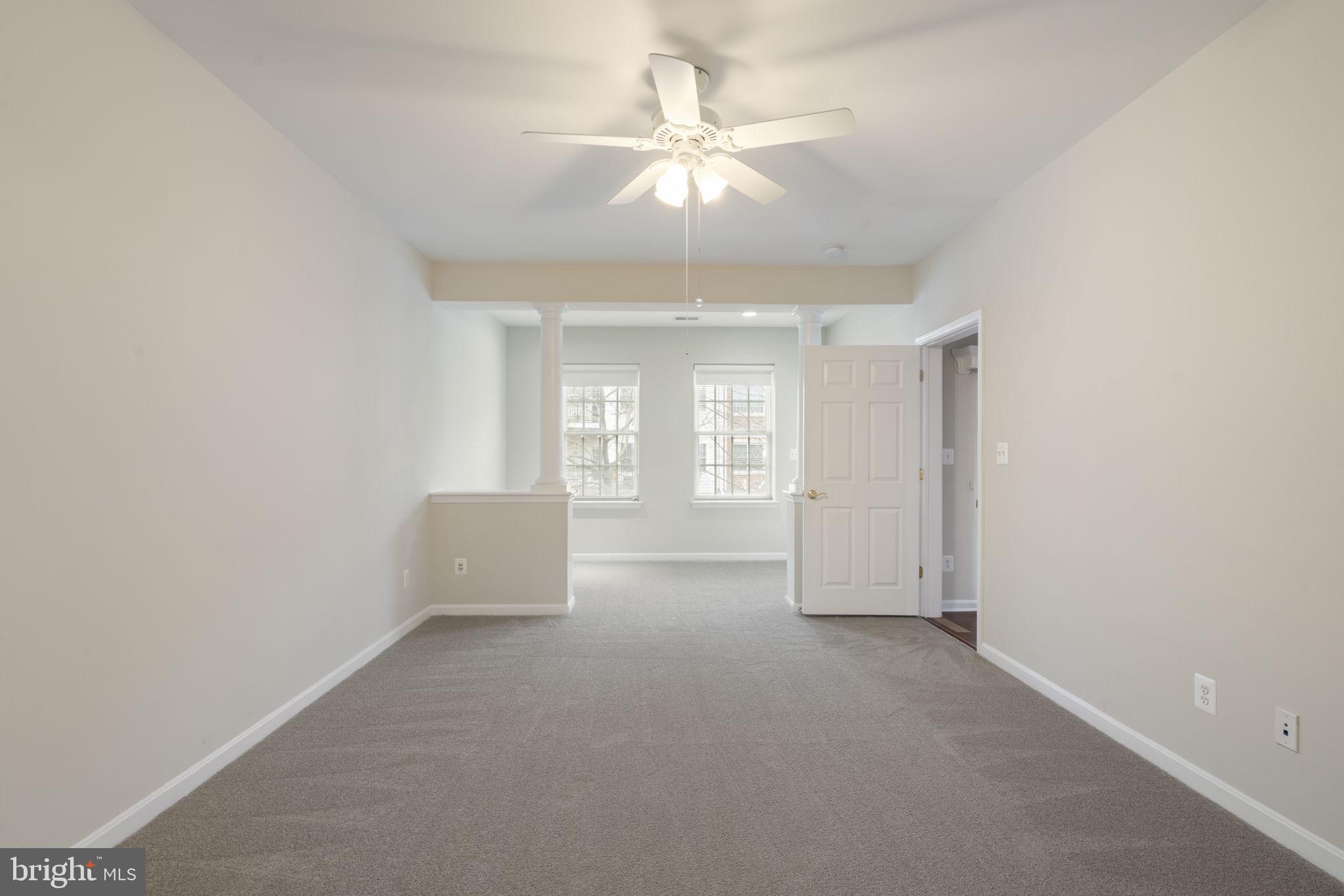 20751 Royal Palace Square, Unit 104 Sterling, VA 20165 - Photo 25 of 44 an empty room with windows and ceiling fan