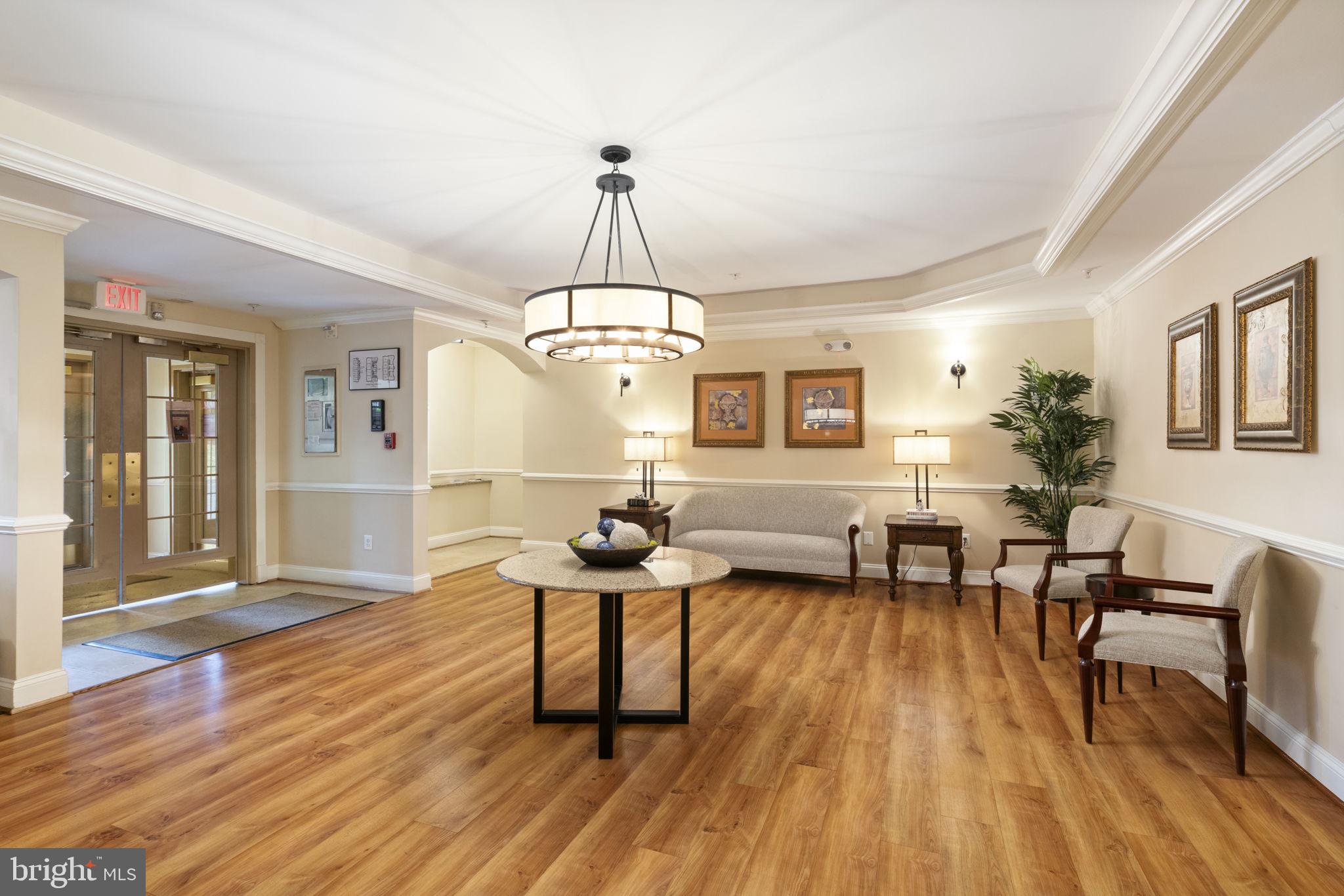 20751 Royal Palace Square, Unit 104 Sterling, VA 20165 - Photo 42 of 44 a dining room with wooden floor a chandelier a wooden table and chairs