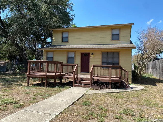 a view of a house with a yard and deck area