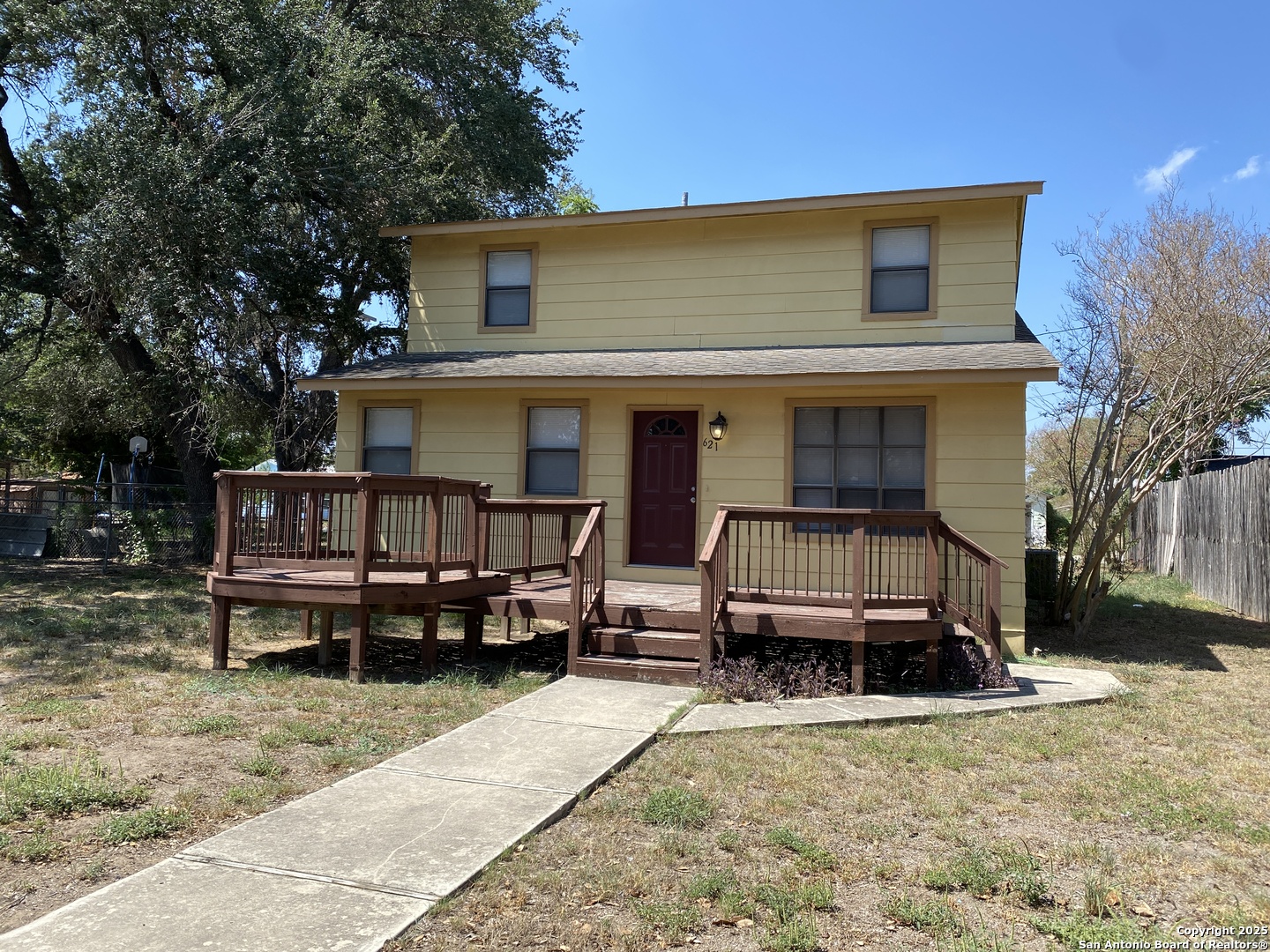 a view of a house with a yard and deck area
