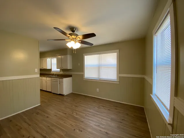 a kitchen with kitchen island white cabinets and wooden floor