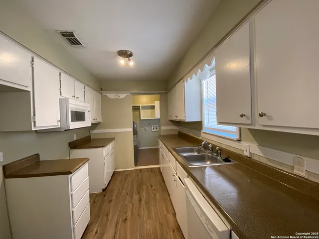a kitchen with a sink stove top oven and cabinets