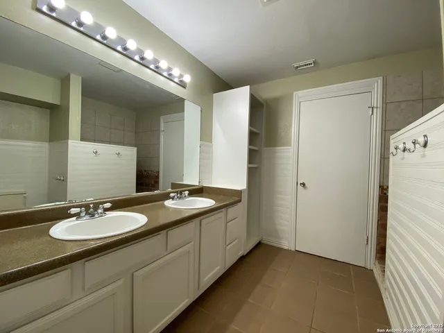 a bathroom with a double vanity sink and a mirror