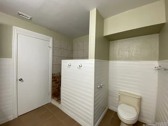 a white toilet sitting next to a shower