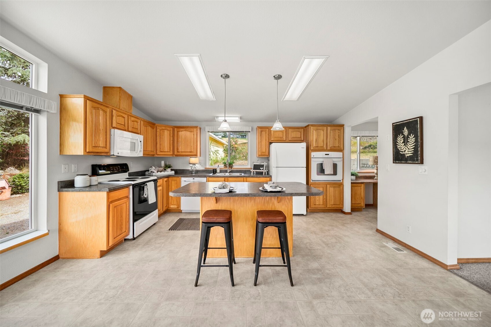 756 Totem Pole Road Manson, WA 98831 - Photo 12 of 39 a kitchen with a table chairs refrigerator and cabinets