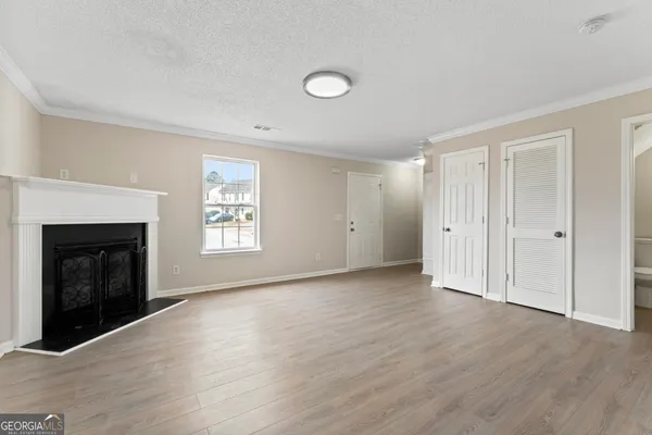 an empty room with wooden floor and fireplace