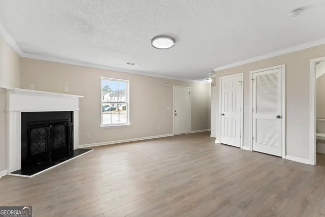 an empty room with wooden floor and fireplace