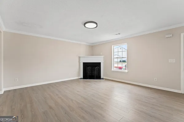 an empty room with windows and fireplace