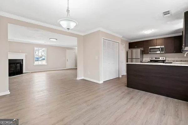 a kitchen with granite countertop a refrigerator and a stove top oven