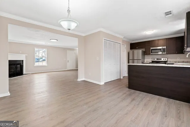 a kitchen with granite countertop a refrigerator and a stove top oven