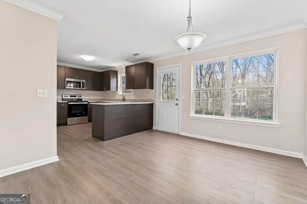a view of kitchen with wooden floor and electronic appliances