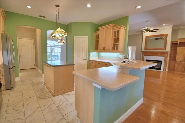 an empty room with chandelier fan and windows