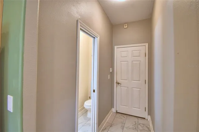 a view of an empty room and chandelier fan