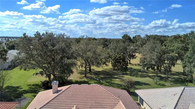 a view of an empty room with wooden floor fireplace and a window