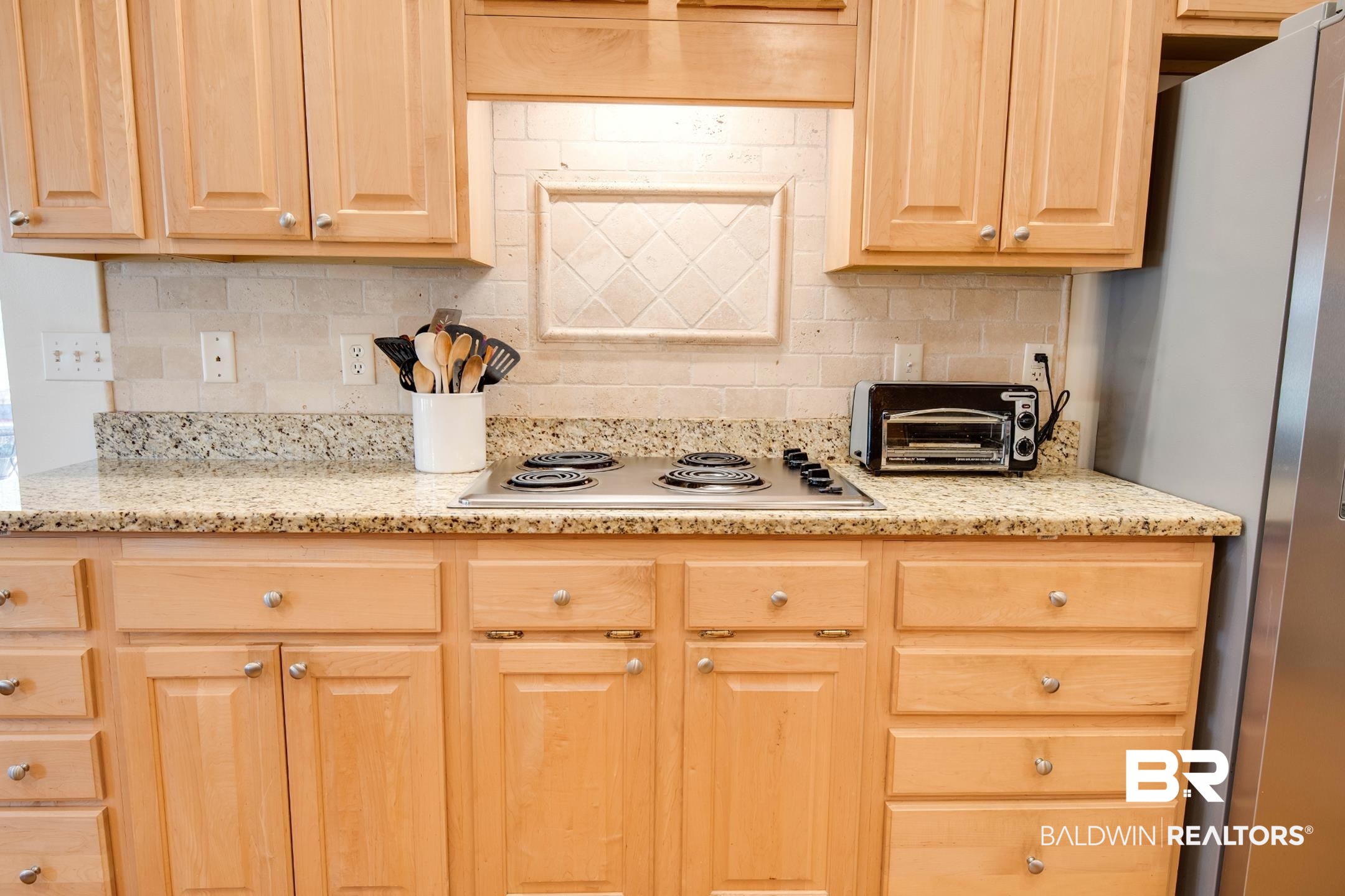 12626 Hunters Chase Foley, AL 36535 - Photo 13 of 40 Kitchen featuring stainless steel appliances, light stone countertops, light wood finish cabinets, and tasteful backsplash