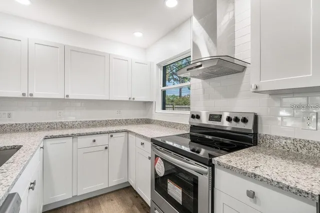 a kitchen with granite countertop cabinets stainless steel appliances and wooden floor