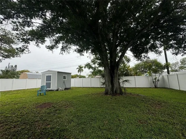 a view of a house with a big yard and large trees